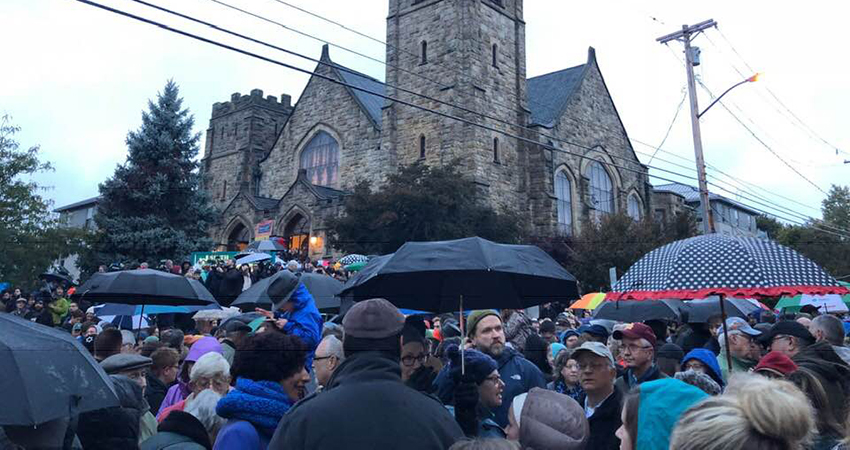 Large crowd of people who gathered in the rain for the Saturday night vigil at the corner of Forbes and Murray in response to the Tree of Life shooting