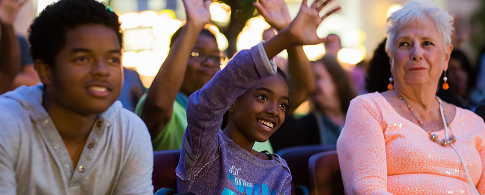 Audience members participate by raising their hands at the Three Rivers Arts Festival.
