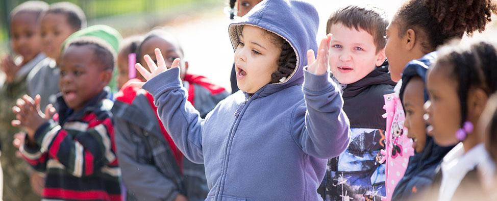 Happy, smiling kindergarten students sing and clap as they wait for the Storymobile to arrive at Propel Elementary School in Hazelwood.