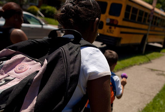 Photo taken from behind of children boarding their school bus to attend the Environmental Charter School.
