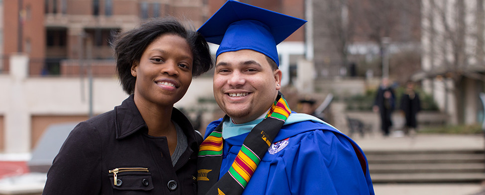 Heinz Fellow, Matthew Tansey, and a guest smiling at his Duquesne University graduation.
