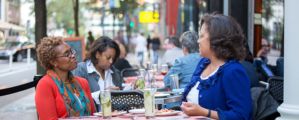 Three woman having lunch on a sunny day at the outside tables on Penn Avenue.