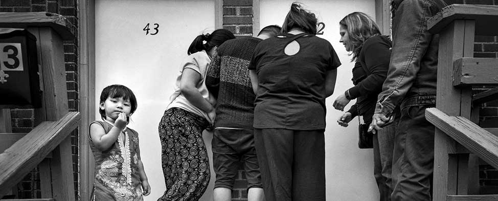 A Bhutanese refugee family uses the key to their new apartment in the Brentwood neighborhood of Pittsburgh; they previously lived in a Beldangi refugee camp in the Damak region of eastern Nepal where there are no locks on the doors.