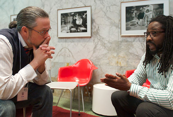 Two men sitting and talking during the family engagement celebration at the Children's Museum of Pittsburgh.