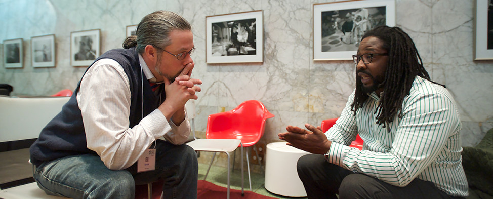 Two men sitting and talking during the family engagement celebration at the Children's Museum of Pittsburgh.