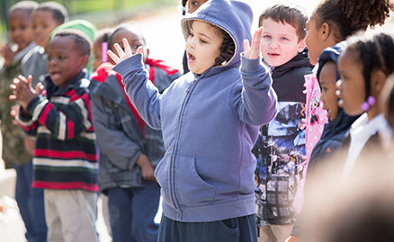 Happy, smiling kindergarten students sing and clap as they wait for the Storymobile to arrive at Propel Elementary School in Hazelwood.