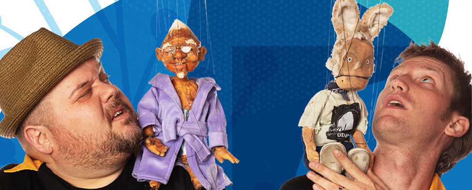 Two men are looking up at the string puppets from "The Dragon of Polish Hill" that are sitting on their shoulders.