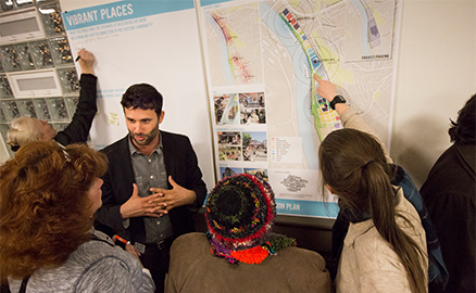 Hazelwood community members talking to developers about the Hazelwood Green development. They are pointing to different sections of the master plan and writing comments.