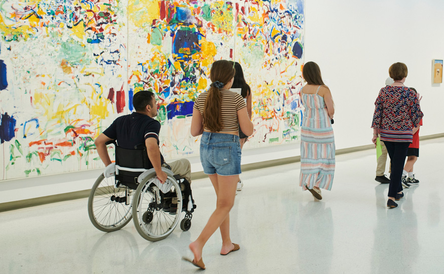 Image of patrons walking through the art filled corridors of the Carnegie Museum of Art