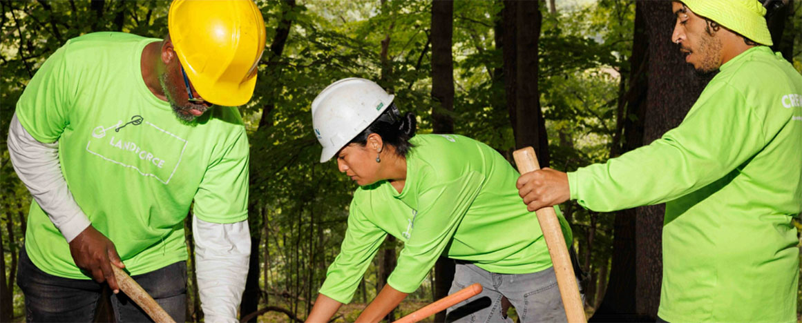 Landscaping students working outside in green shirts