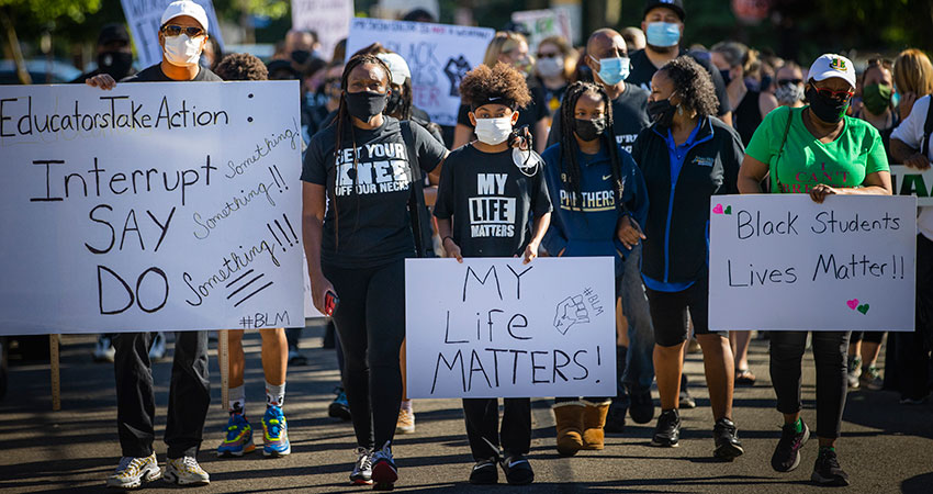 Protesters holding signs and marching in Pittsburgh. Some of the signs say, "My life matters," and "Black students lives matter."